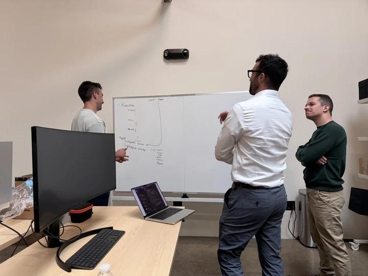 Three Nash engineers working through a system architecture problem at a whiteboard